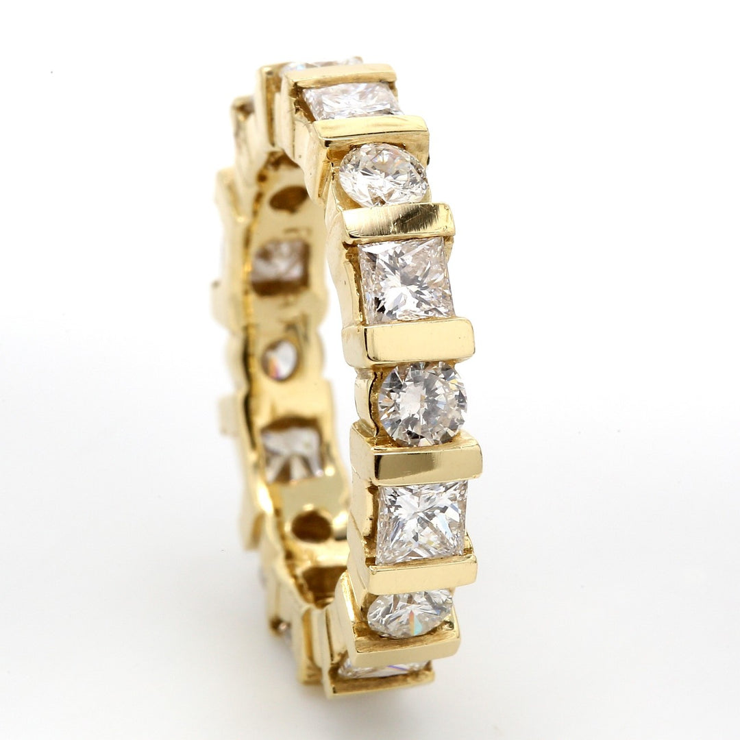Eternity band in 14K YG with alternating channel set round & princess cut diamonds. D2.60ct.t.w. Size 5.75