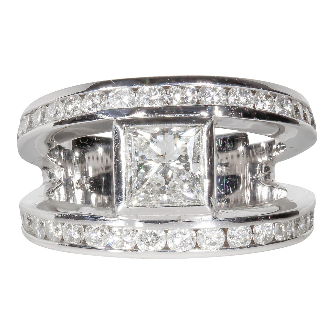 Open shank ring with channel set rounds and bezel set princess cut diamond center stone. D2.24ct.t.w. (Center 0.96ct.)
