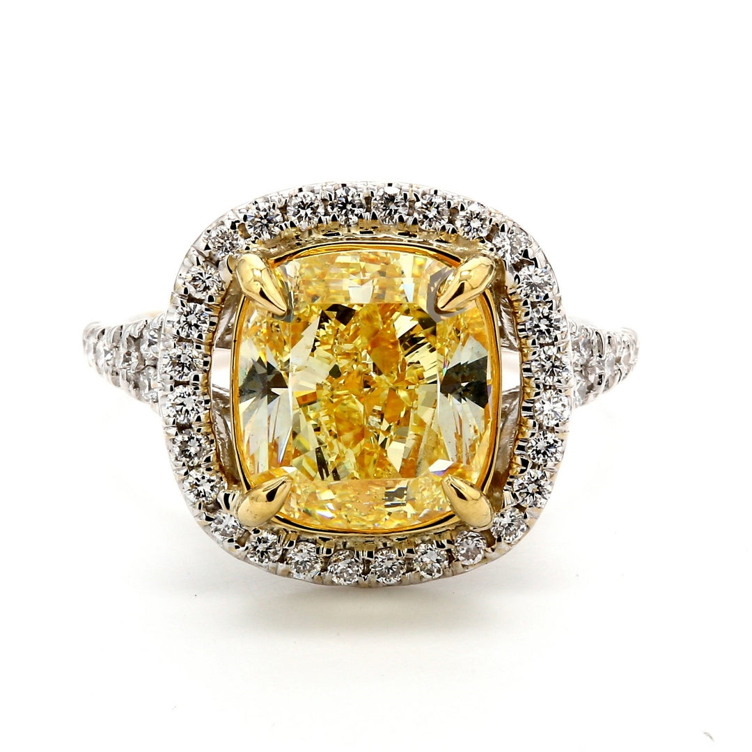 Halo ring in 18K WG with 4-prong set GIA certified FY/SI1 cushion center & prong set round diamonds. D5.61ct.t.w. (Center 5.04ct.) Size 6.75