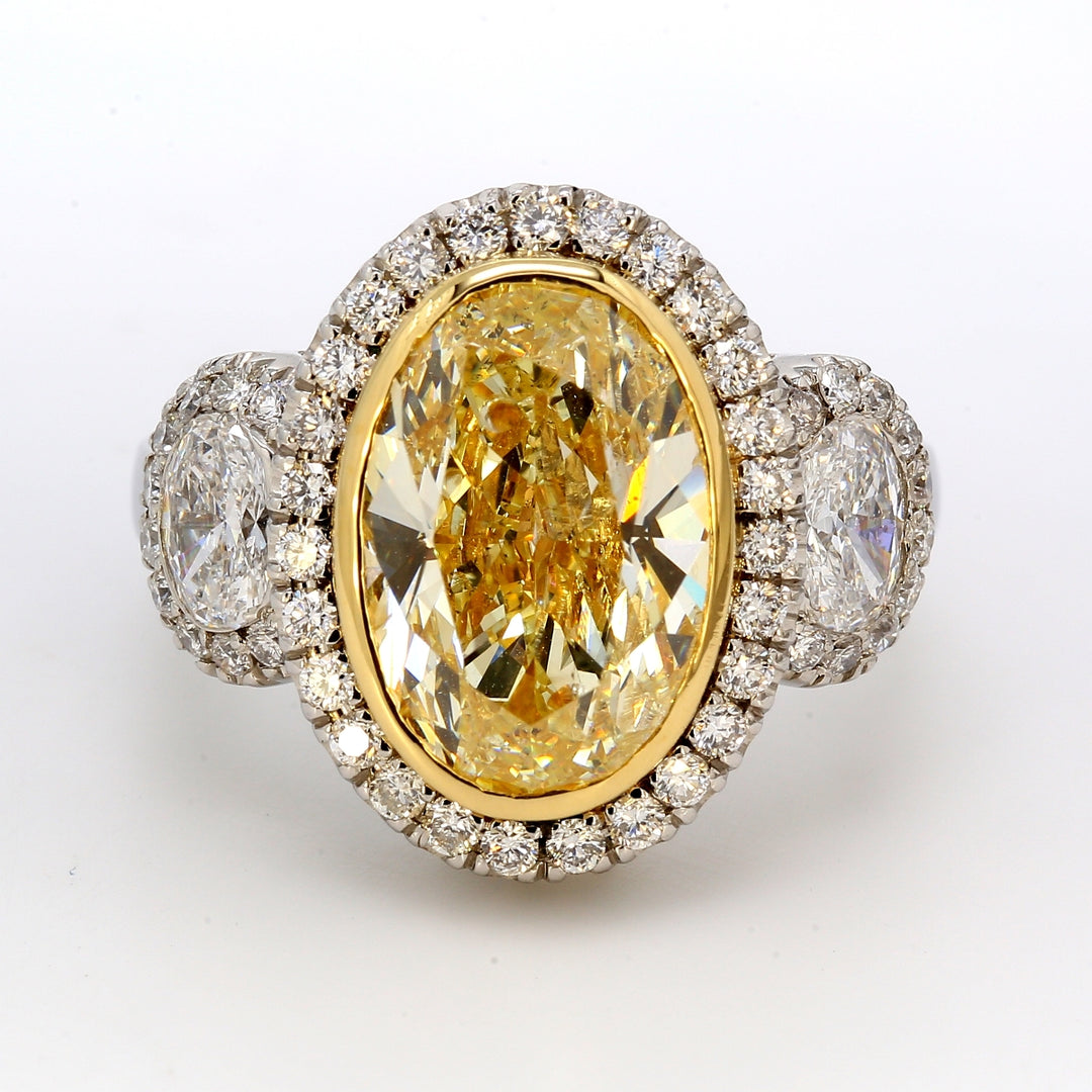 3-stone halo ring in platinum with GIA certified FY/SI2 oval center & oval diamond sides. D6.36ct.t.w. (Center 5.02ct.)