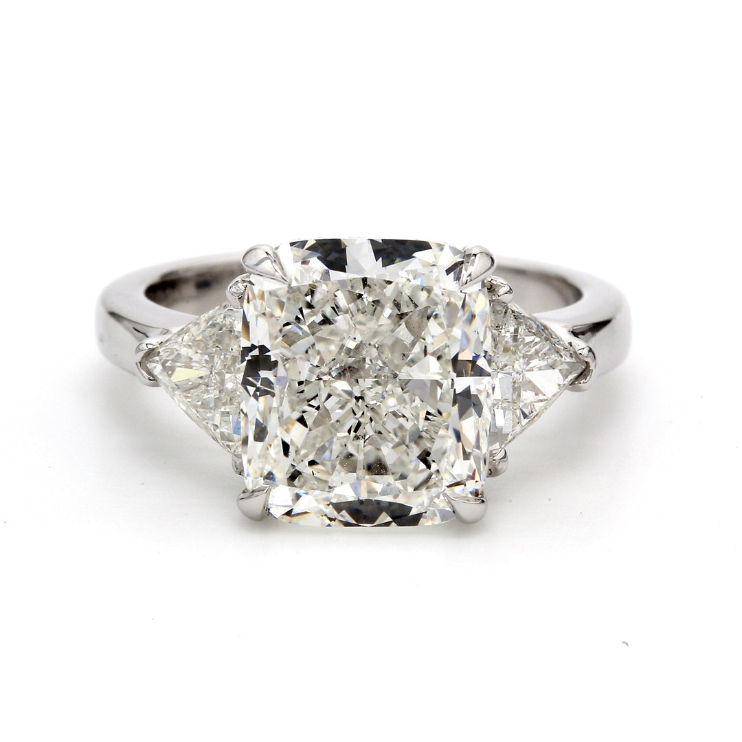 3-stone ring in platinum with claw set GIA certified H/SI1 cushion center and 3-prong set trilliant diamond sides. D8.13ct.t.w. (Center 7.01ct.)