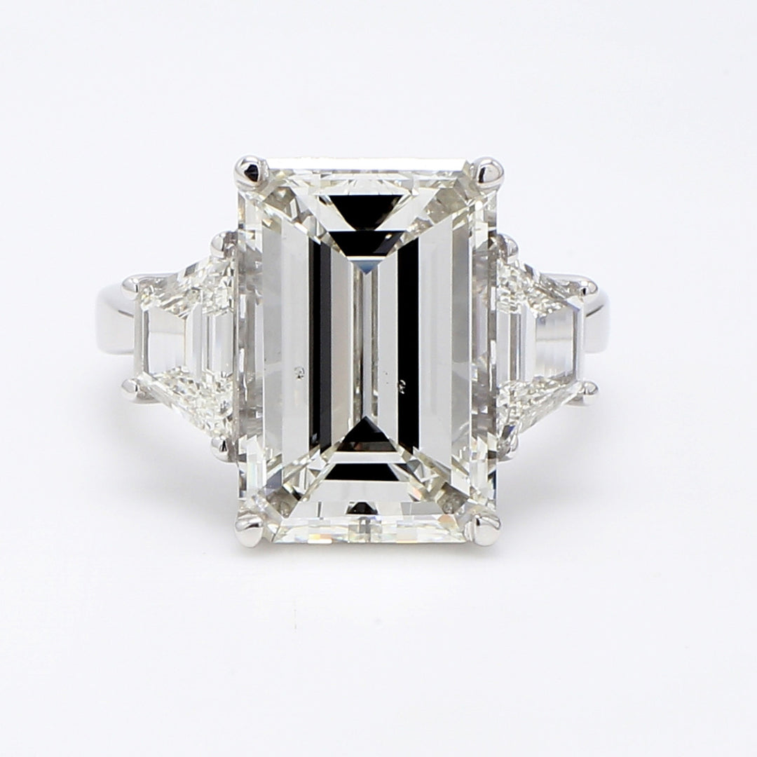 3-stone ring in platinum with GIA certified J/SI1 emerald center and step cut trapezoid diamond sides. D9.15ct.t.w. (Center 8.02ct.)