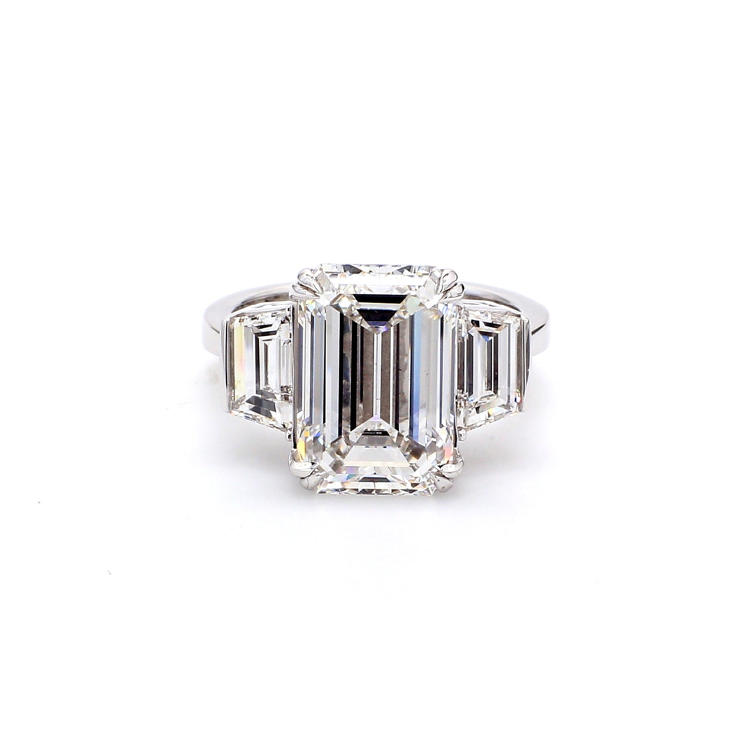 3-stone ring in platinum with double 4-prong set GIA certified F/VS2 emerald cut center and channel set trapezoid diamond sides. D8.44ct.t.w. (Center 7.06ct.)