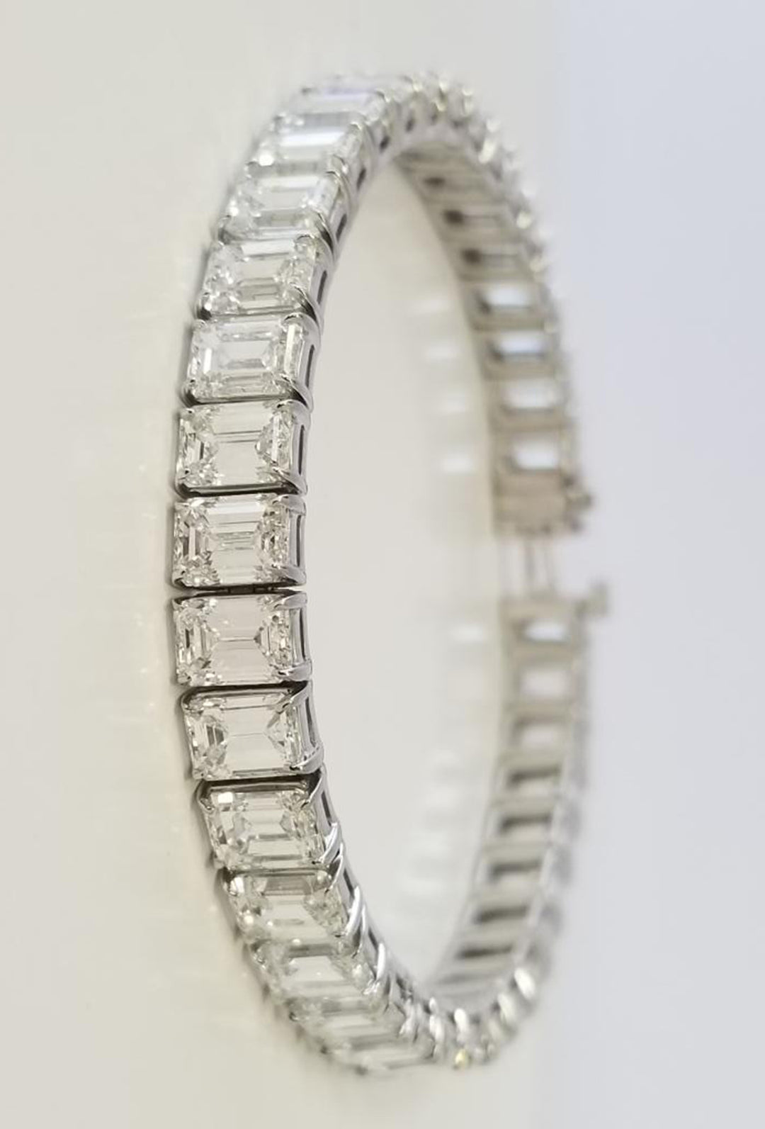 7"" Tennis bracelet in platinum with basket prong set GIA certified G-I/VVS1-VS2 (43) emerald cut diamonds. D21.83ct.t.w.