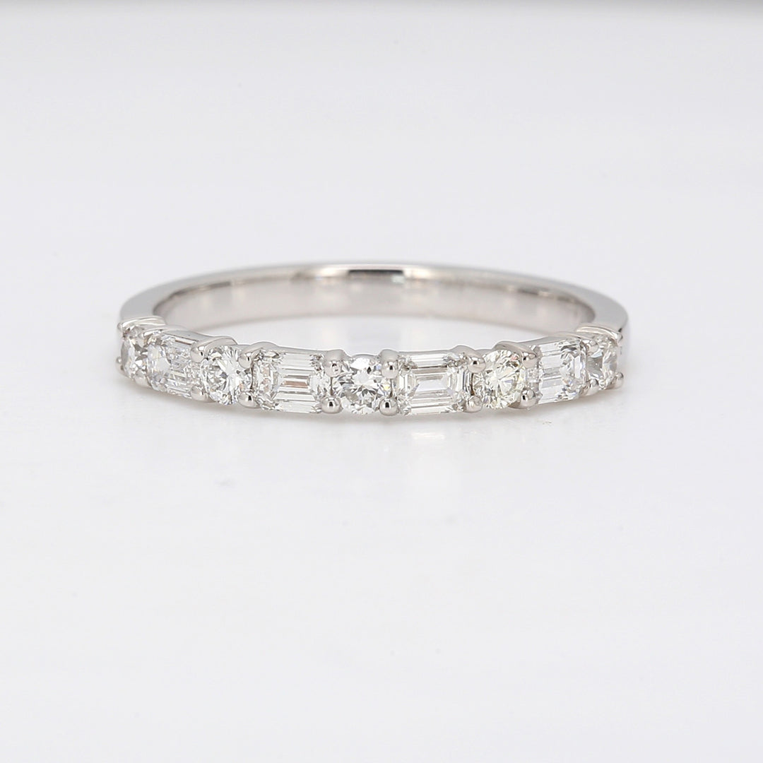 Band in platinum with alternating prong set round and emerald cut diamonds. D0.60ct.t.w.