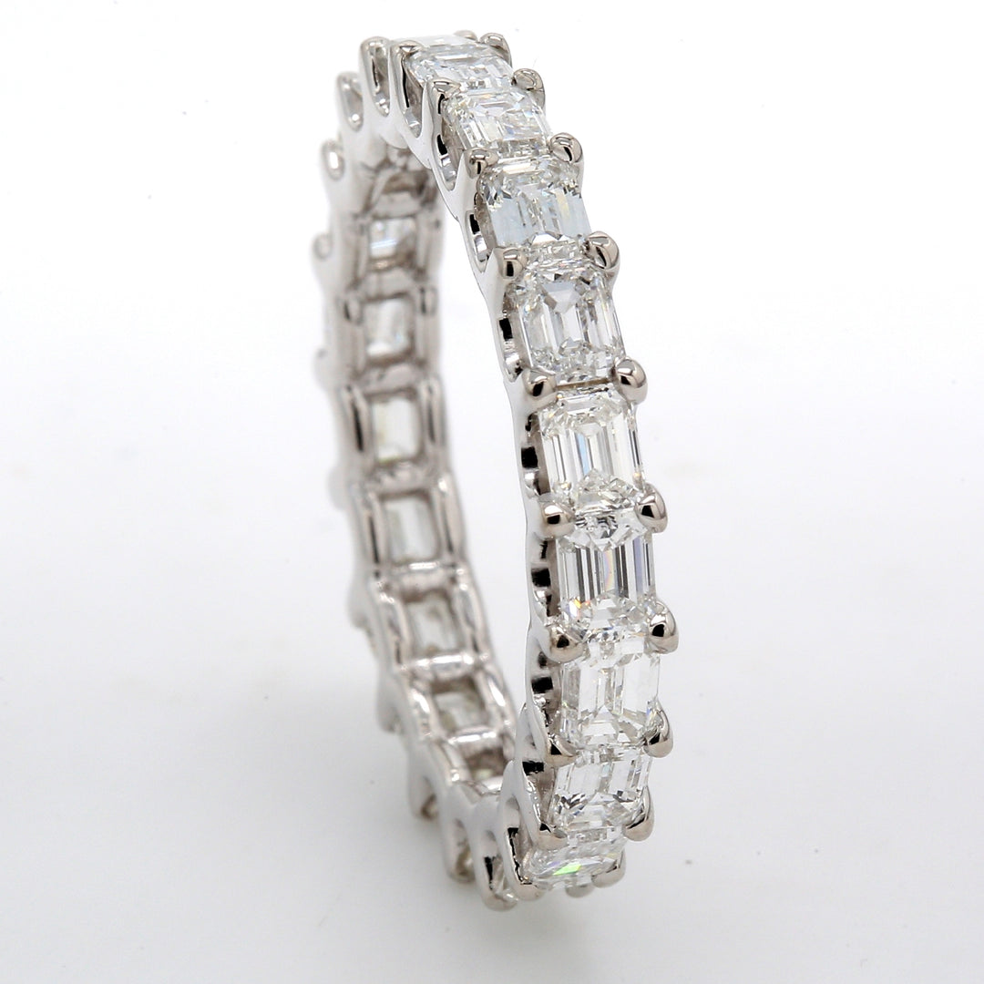 East to west style eternity band with shared U-prong set (21) emerald cut diamonds. D3.14ct.t.w. Size 7.5