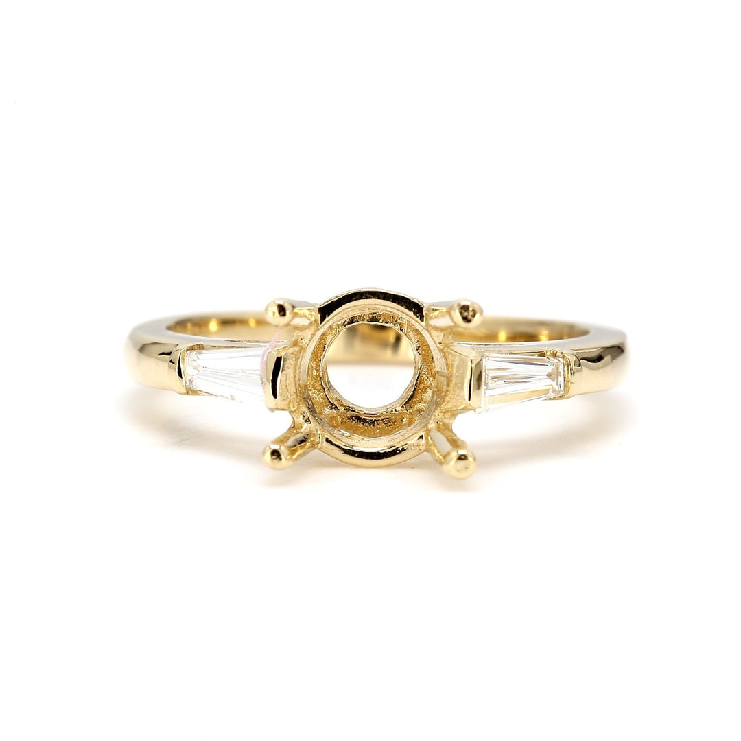 3-stone semi-mount in yellow gold with channel set tapered baguette diamond sides. D0.24ct.t.w.