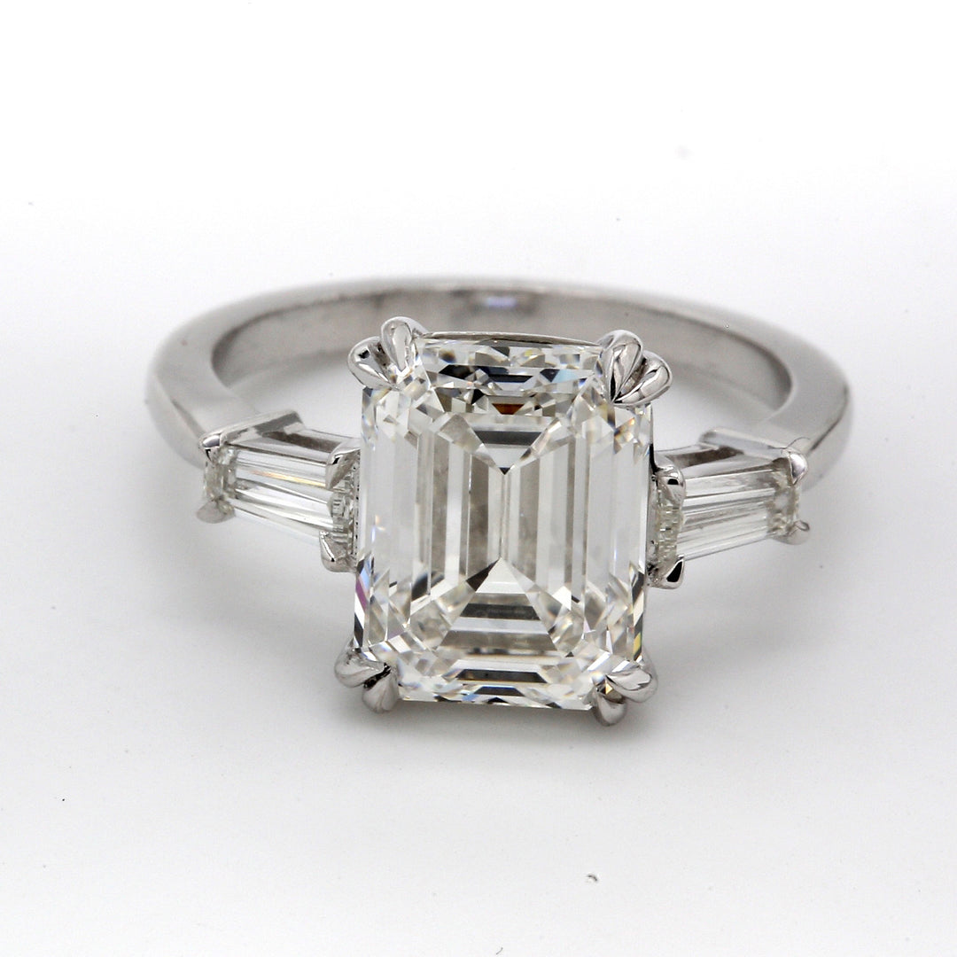 3-stone ring in platinum with GIA certified I/VS1 emerald cut center and tapered baguette diamond sides. D5.39ct.t.w. (Center 5.01ct.)