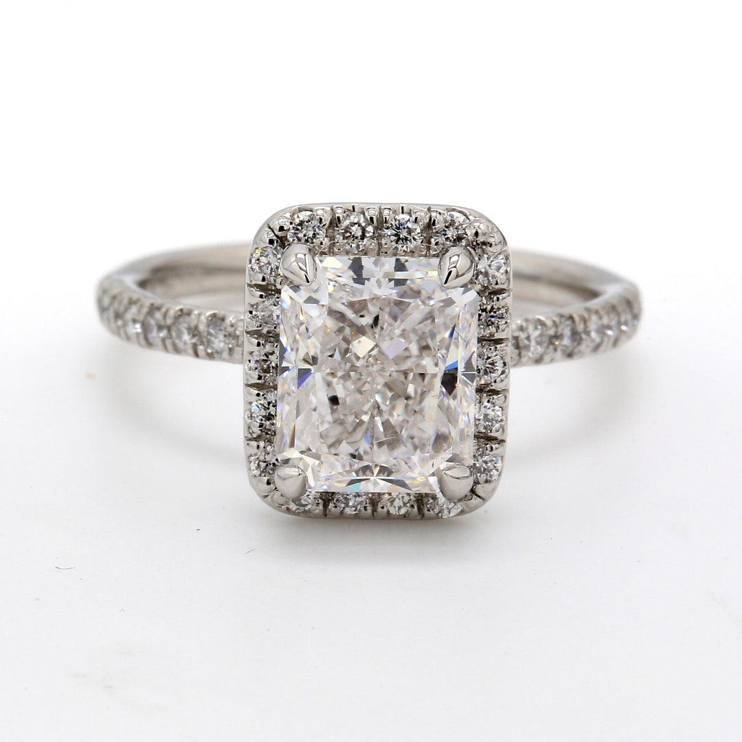Halo ring in platinum with GIA certified F/SI2 radiant cut center and U-prong set round diamonds. D3.48ct.t.w. (Center 3.02ct.) Size 6.75