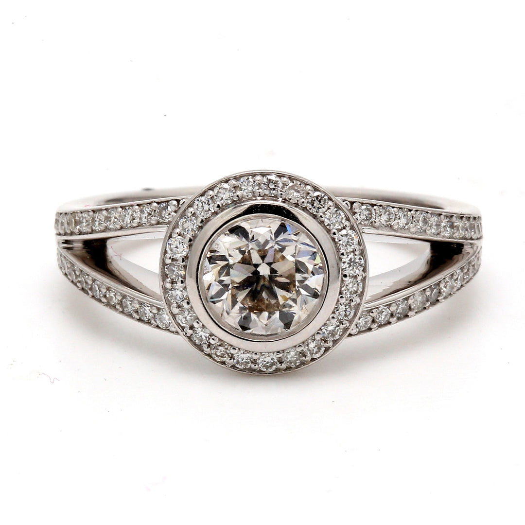 Halo ring with pre-set rounds on the shank and bezel set round diamond center stone. D1.42ct.t.w. (Center 1.01) Size 8