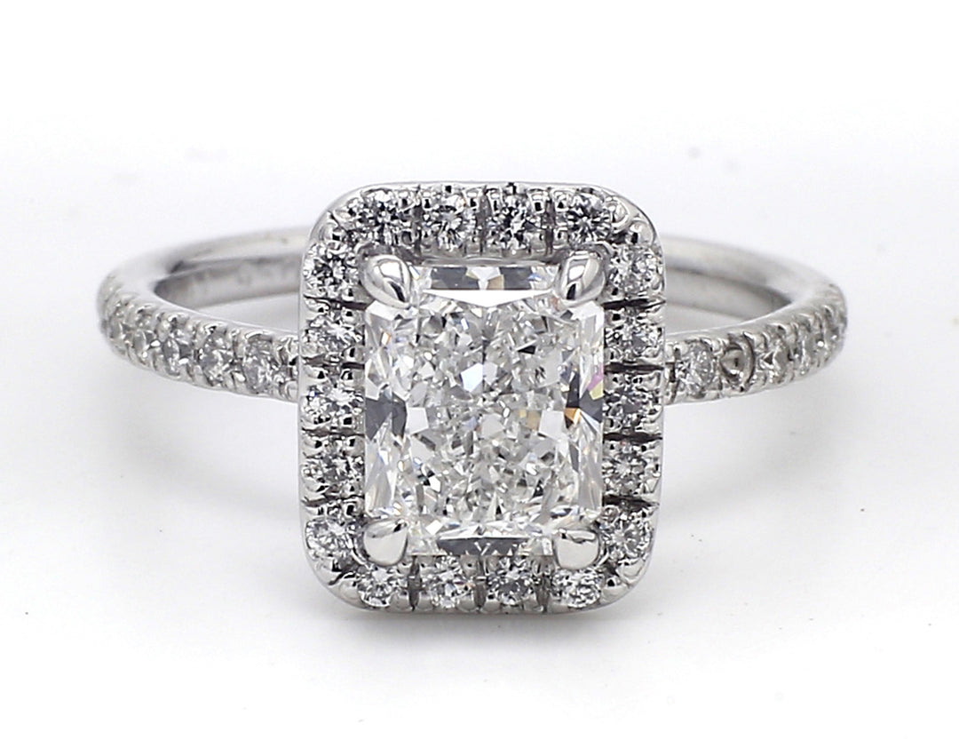 Halo ring in platinum with pre-set rounds around GIA certified E/SI1 radiant diamond center. D2.47ct.t.w. (Center 2.01ct.)