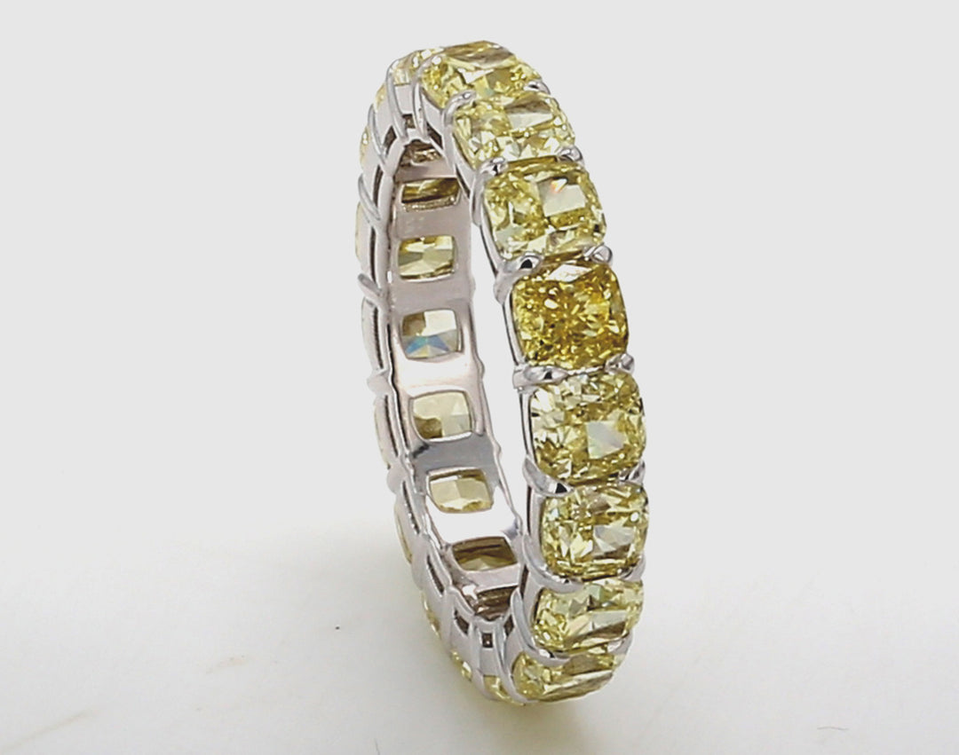 Eternity band in 18K WG with shared prong set fancy yellow (18) cushion cut diamonds. D6.04ct.t.w. Size 5.75