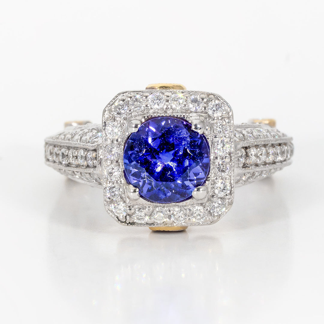 Antique style ring in Platinum and 18K YG linings with pave and bezel set round diamonds, and 4-prong set round shaped tanzanite center stone.  D1.52ct.t.w.  Tanzanite 1.40ct.