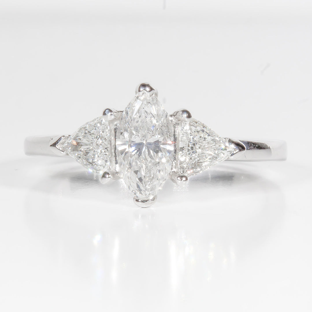 3-stone ring in platinum and 18K WG with 2-prong set marquise center stone and 3-prong set trilliant cut diamonds on the sides.  D1.07ct.t.w.  (Center 0.69ct.)
