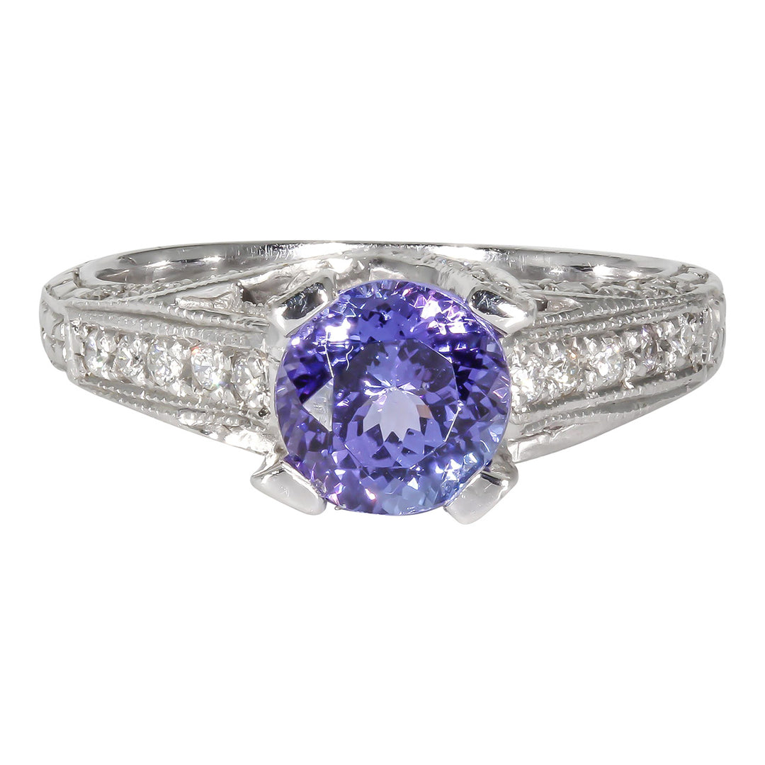 Engraved antique style ring in platinum with pave set round diamonds and U-prong set round shaped tanzanite center stone.  D0.52ct.t.w.  Tanzanite 1.46ct.