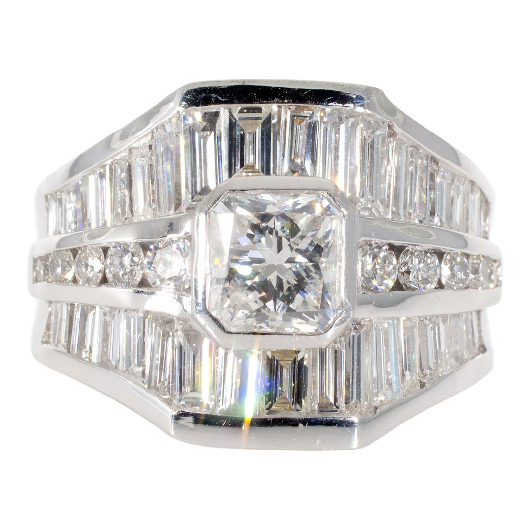 Ring with channel set combination baguette and rounds, and a square bezel set radiant cut diamond center stone.  D2.24ct.tw.  Center 1.20ct.