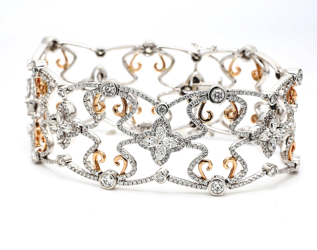 8"" Designer bracelet in 18K two-tone with French pave set round diamonds around flower design prong set marquise diamond center stones.  D9.56ct.t.w.