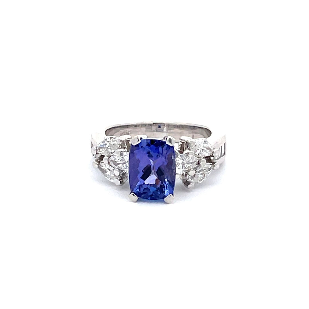 Ring in platinum with channel set baguettes, prong set marquise and pear diamonds & 4-prong set cushion shape tanzanite center.   D1.03ct.t.w.  (Tanzanite - 2.96ct.)