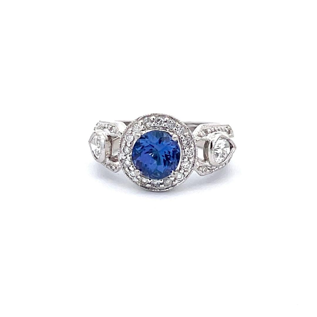 Halo ring in platinum with pave set rounds, bezel set pear shape diamonds, and 4-prong set round shape tanzanite center.  D1.03ct.t.w.  (Tanzanite - 1.70ct.)