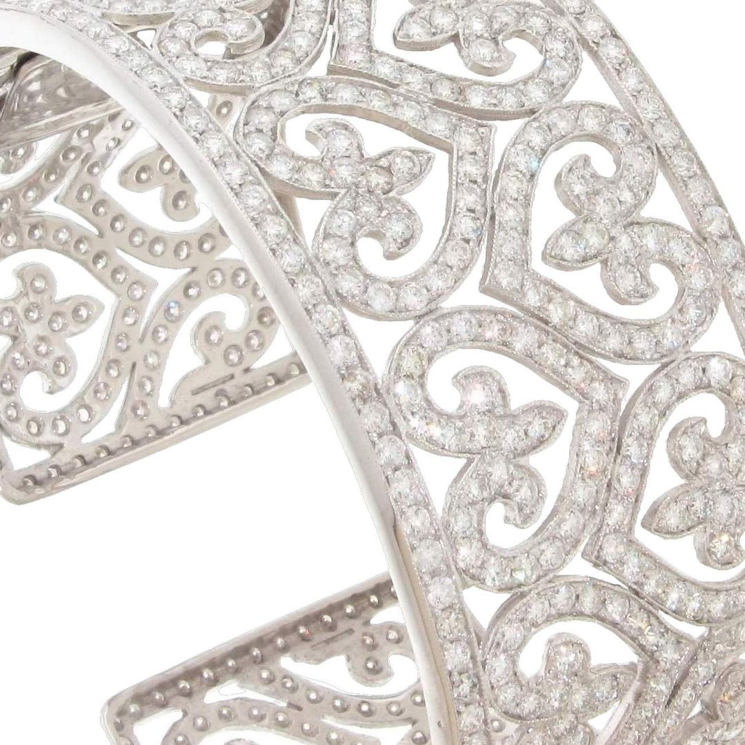 Designer cuff with heart design, milgrain detail, and pave set round diamonds.  D6.55ct.t.w.