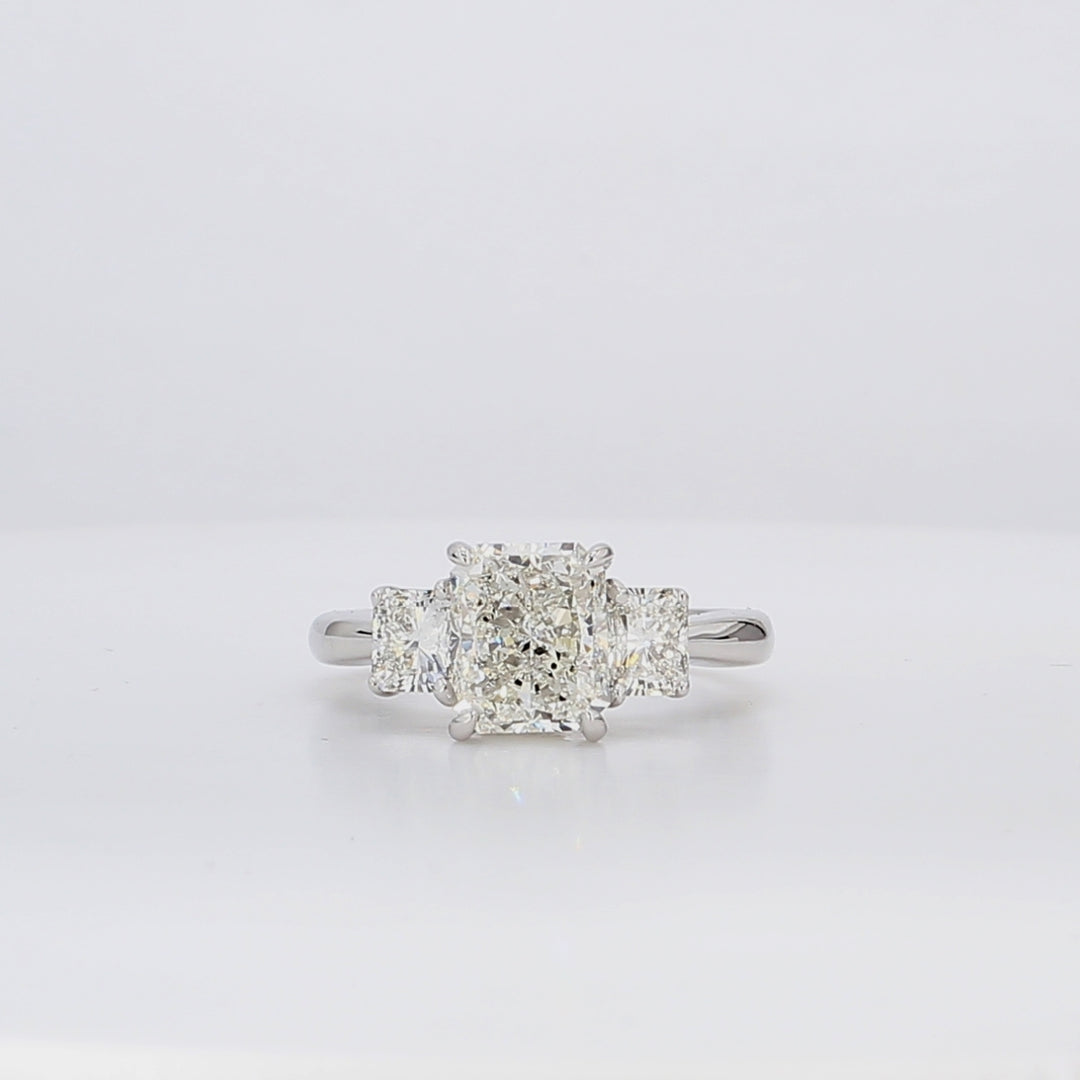 3-stone semi-mount in 18K WG with radiant cut diamond sides.  D1.01ct.t.w.