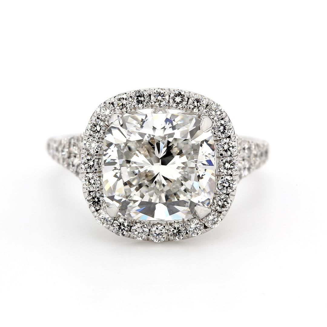Halo split shank ring in 18K WG with 4-prong set GIA certified H/VS2 cushion cut center and U-prong set round diamonds.  D5.66ct.t.w.  (Center 4.83ct.)  Size 6.5
