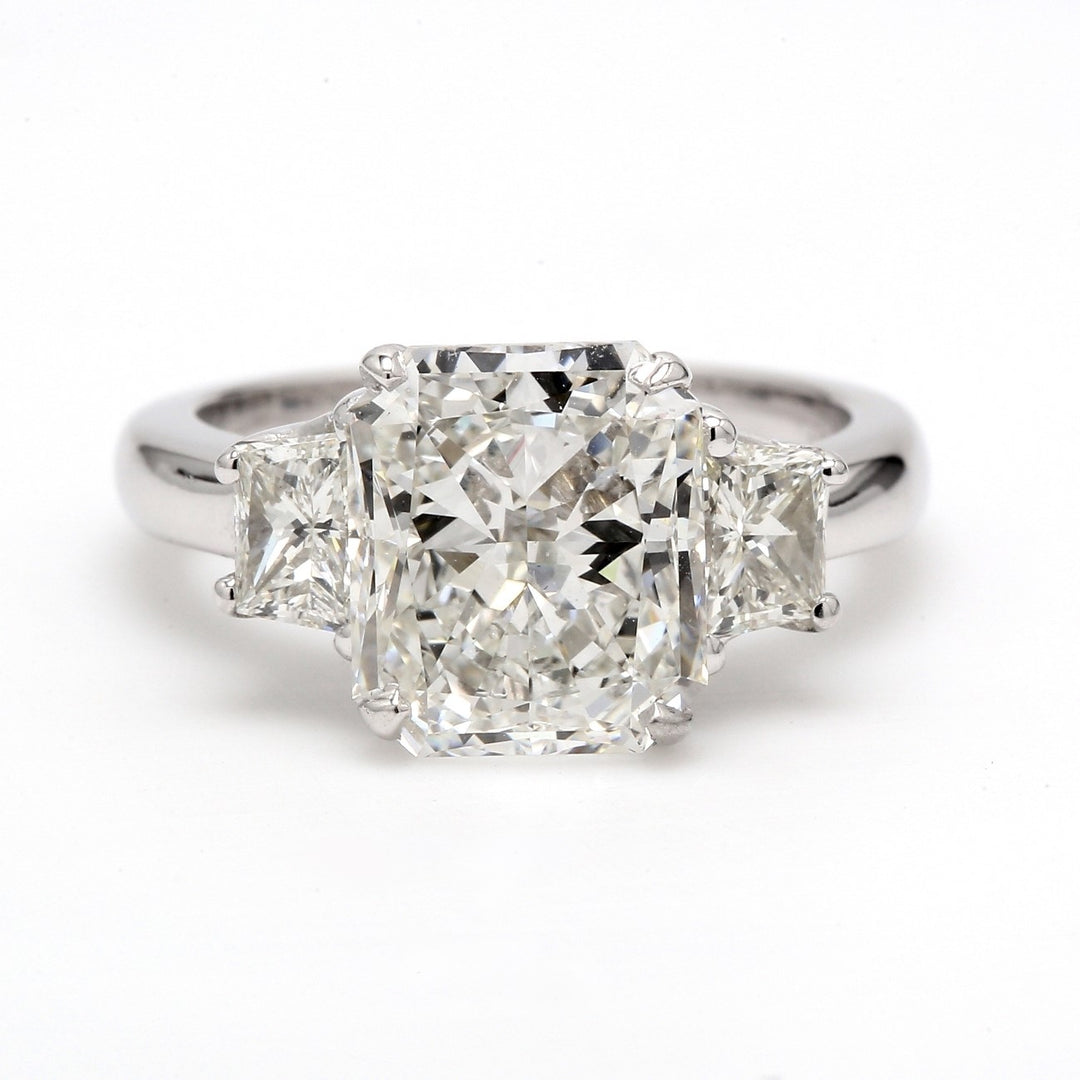 3-stone semi-mount in 18K WG with prong set trapezoid cut diamond sides.  D0.93ct.t.w.