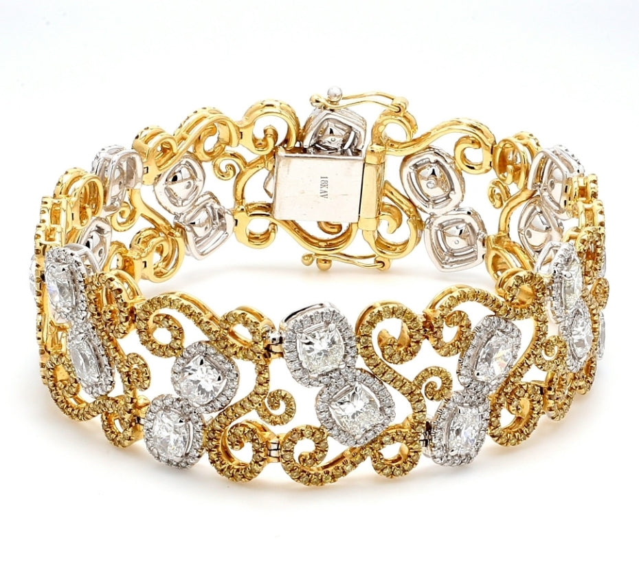 Designer swirly style halo bracelet in 18K 2-tone with french pave set white and yellow rounds around prong set cushion cut diamond centers.  D13.71ct.t.w.