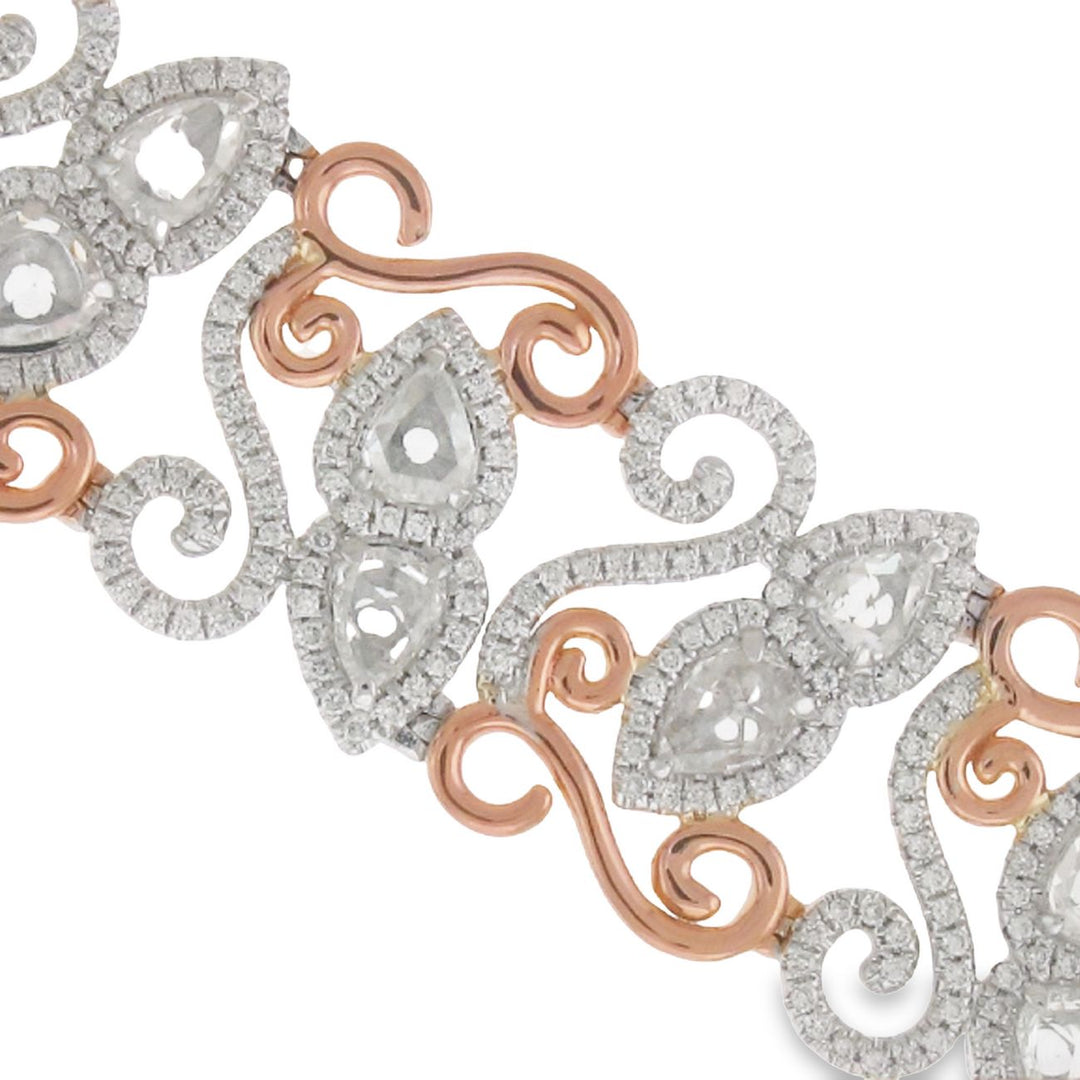Halo designer bracelet in 18K two-tone with swirl gold lining in rose gold, French pave set rounds around prong set pear shape diamond center stones.  D10.83ct.t.w.