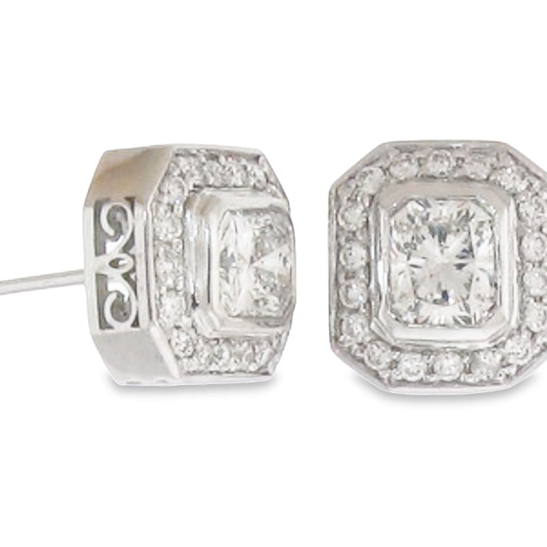 Halo style stud earrings in 18K WG with rounds around bezel set radiant cut diamond center stones.  D1.57ct.t.w.