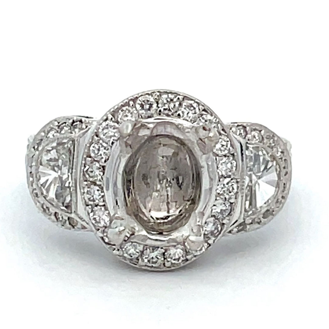 3-stone halo semi-mount with shared prong set rounds and half moon diamond sides.  D1.76ct.t.w.
