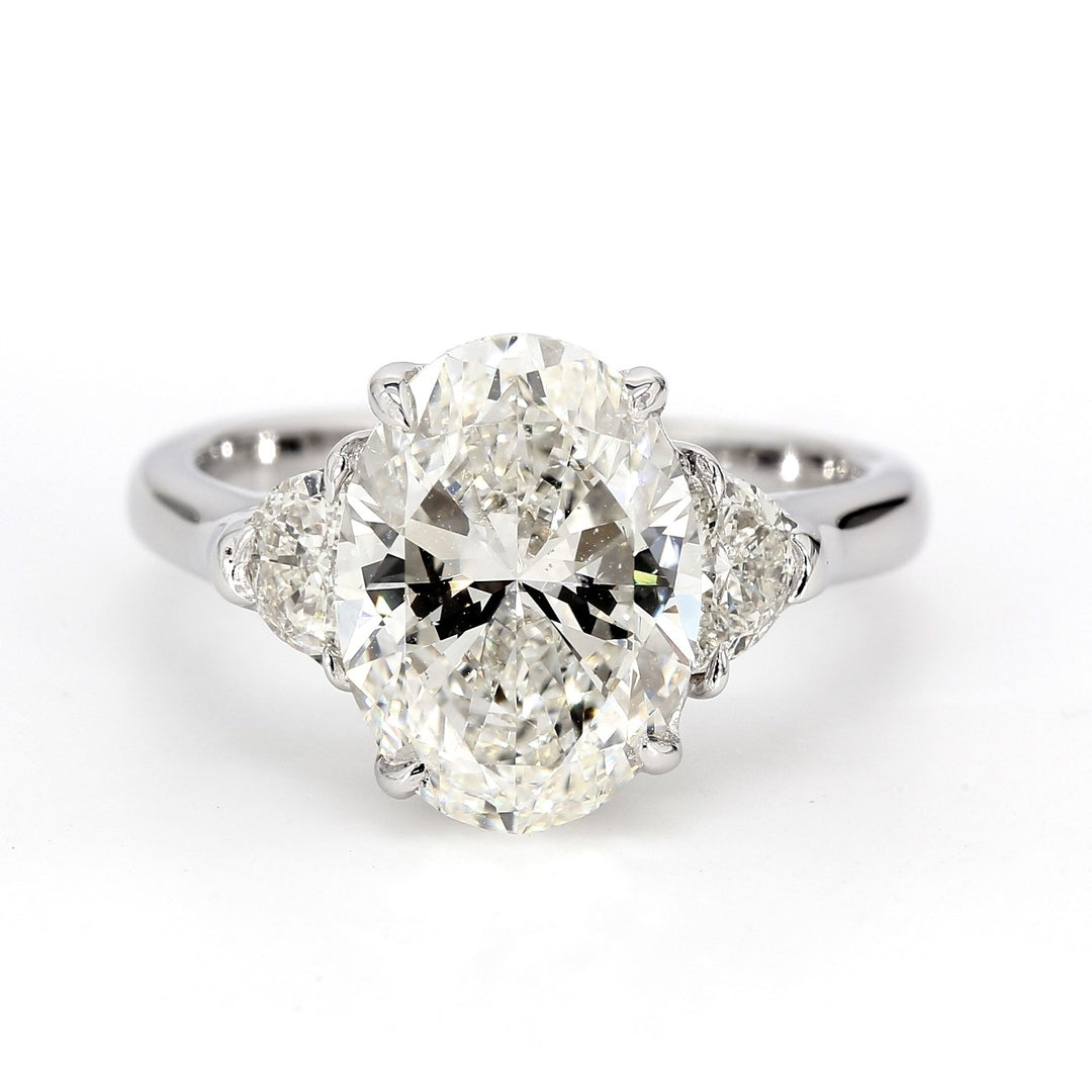 3-stone ring in 18K WG with 4-claw prong set GIA certified H/SI1 oval center and 3-prong set half moon diamond sides.  D4.50ct.t.w.  (Center 4.03ct.)