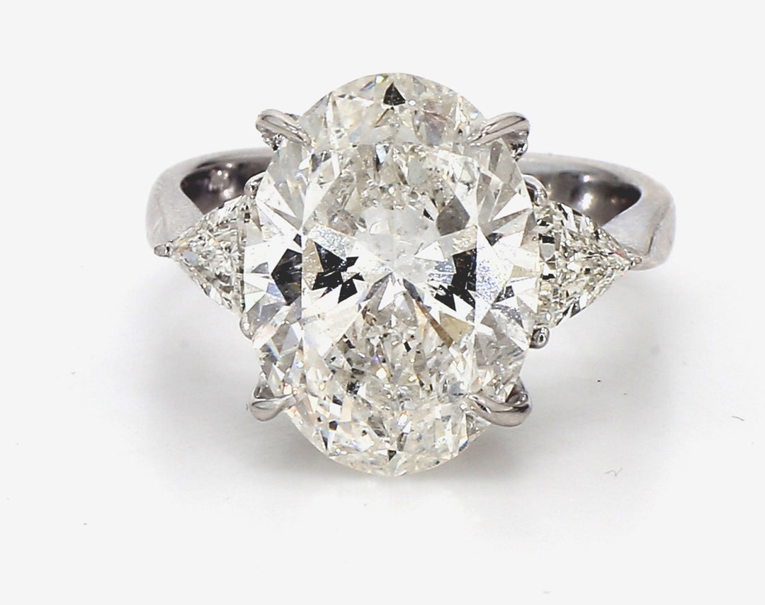 3-stone ring in 18K WG with GIA certified I/SI2 emerald cut center and 3-prong set trilliant cut diamond sides.  D7.63ct.t.w.  (Center 7.03ct.)  Size 7