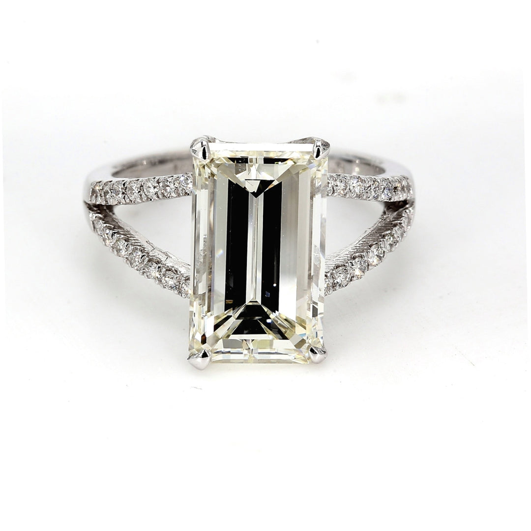 Split shank ring with pre-set rounds and 4-prong set GIA certified L/SI1  emerald cut diamond center.  D5.28ct.t.w.  (Center 5.03ct.)