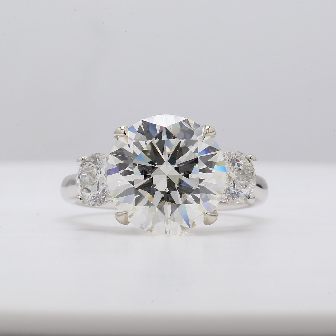 3-stone semi-mount with prong set round diamond sides.  D1.00ct.t.w.