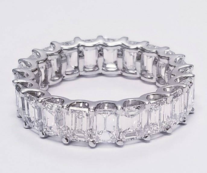 Eternity band in platinum with  shared U-prong set emerald cut diamonds.  D6.79ct.t.w.