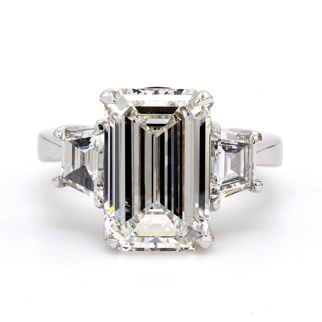 3-stone ring in platinum with claw prong set GIA certified F/VVS2 emerald cut center and prong set step cut trapezoid diamond sides.  D7.05ct.t.w.  (Center 6.01ct.)