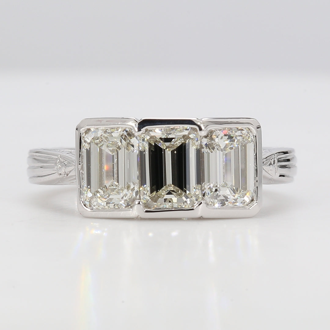 3-stone ring in platinum with half bezel set emerald cut diamonds.  D1.92ct.t.w.  Size 5