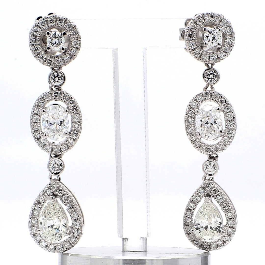 Halo dangling earring with bezel and pave set rounds & 4-prong set oval and pear shape diamonds.  D3.08ct.t.w.