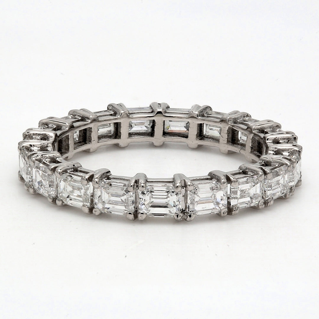 East to west style eternity band in platinum with 4-prong set (18) emerald cut diamonds.  D2.58ct.t.w.  Size 5