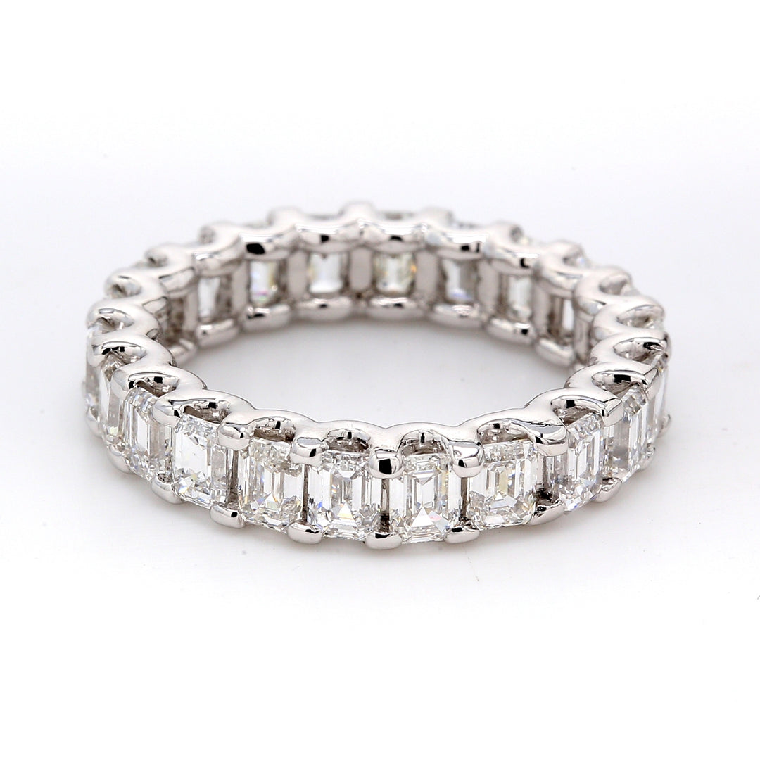 Eternity band in platinum with shared U-prong set emerald cut diamonds.  D4.42ct.t.w.  Size 5.25