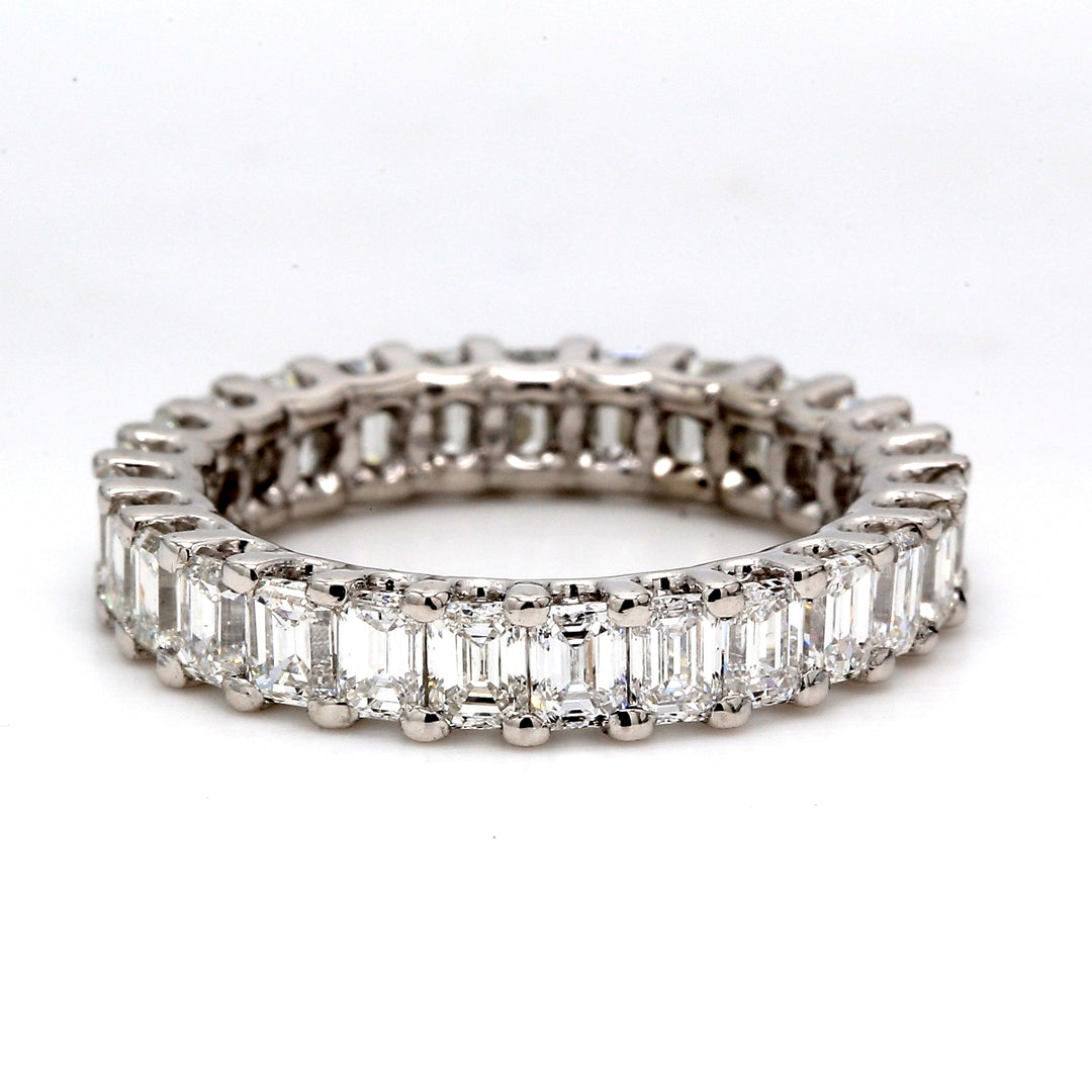 Eternity band in platinum with shared U-prong set emerald cut diamonds.  D3.34ct.t.w.