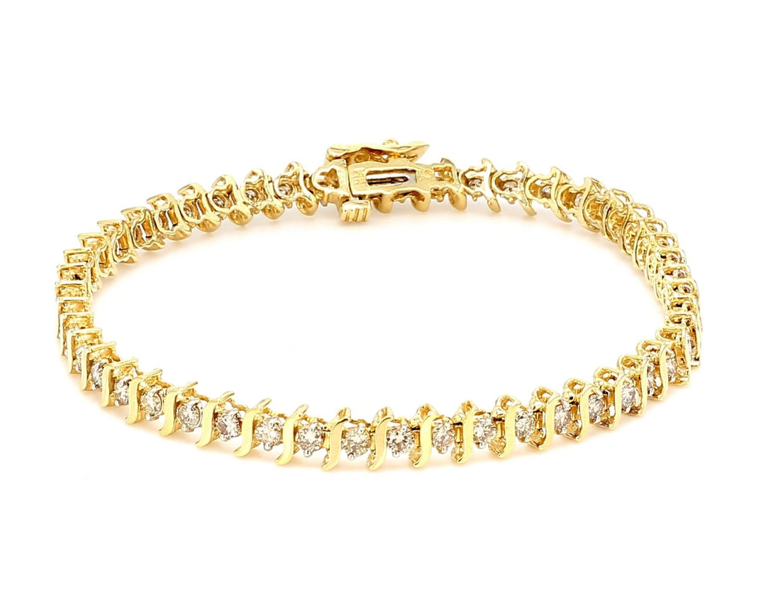 7.5"" Tennis bracelet S-style in yellow gold with channel set round diamonds.  D1.00ct.t.w.