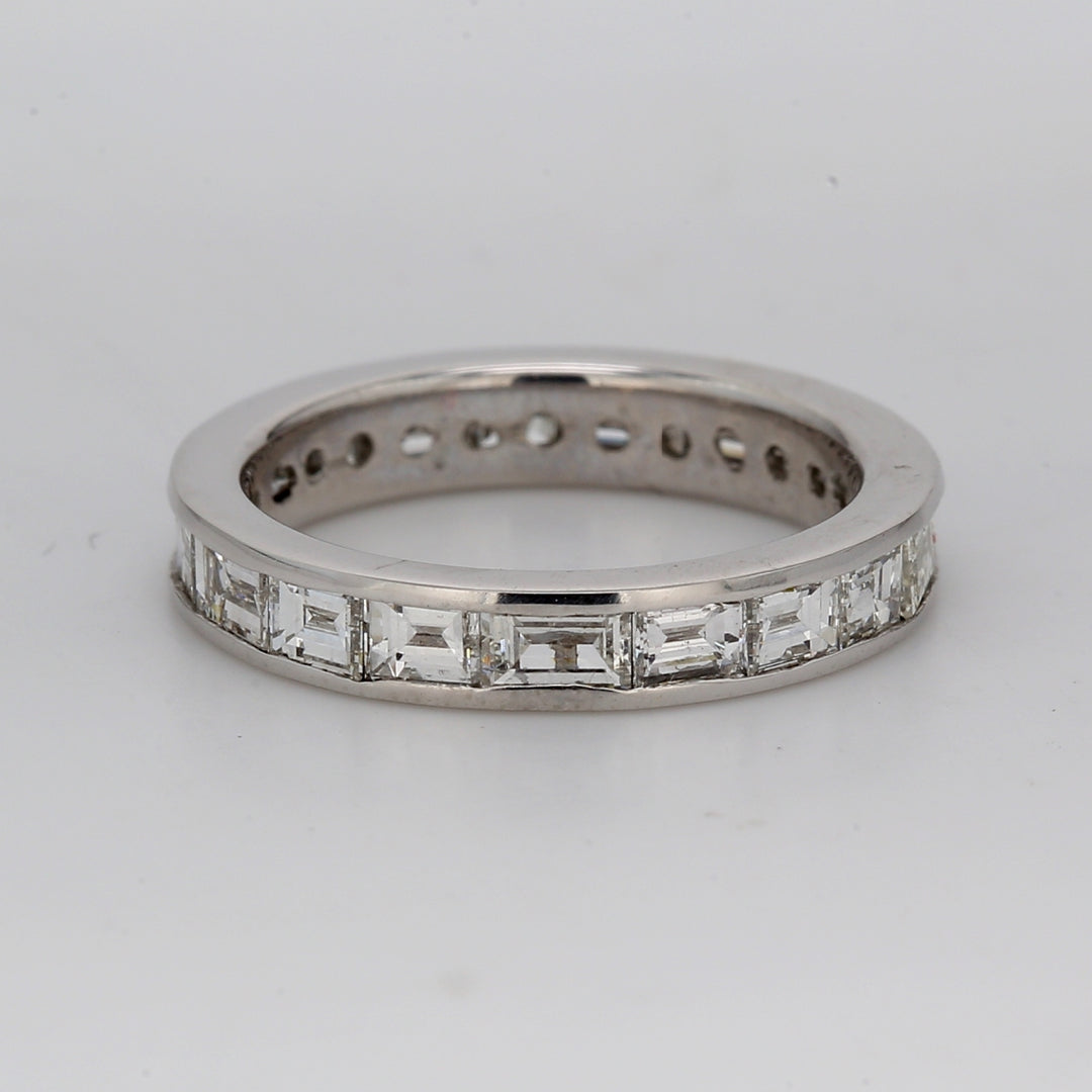 East to west style eternity band in platinum with channel set baguette diamonds & a baguette sapphire.  D1.59ct.t.w.  Sapphire 0.18ct.