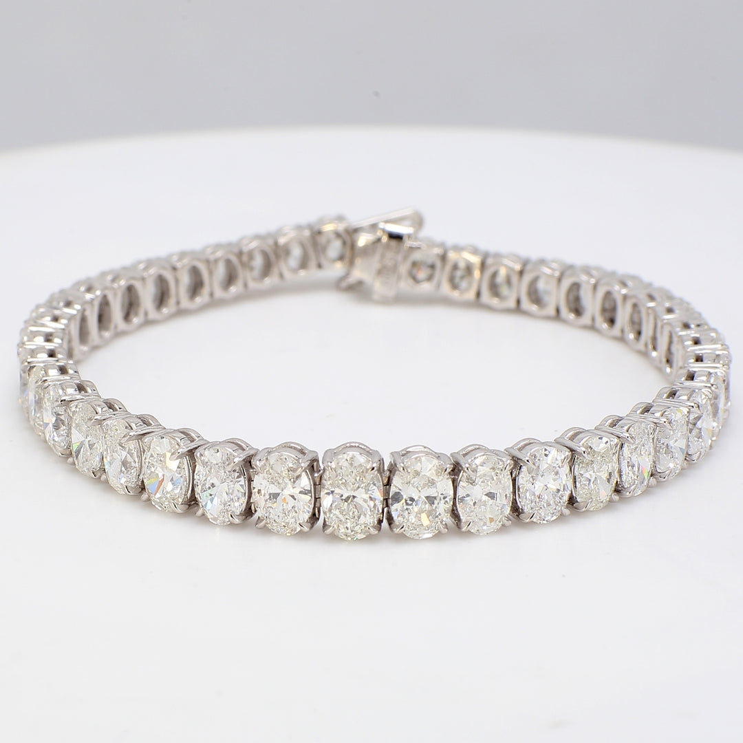 6.5"" Graduated tennis bracelet in platinum with basket shared prong set oval diamonds.  D13.41ct.t.w.