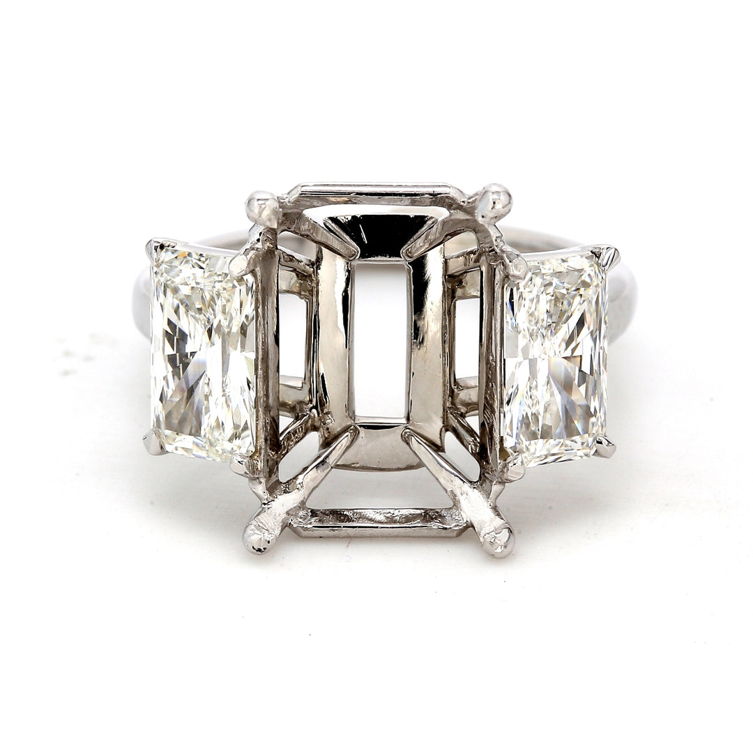 3-stone semi-mount in platinum with 4-prong set radiant cut diamond sides.  D2.09ct.t.w.