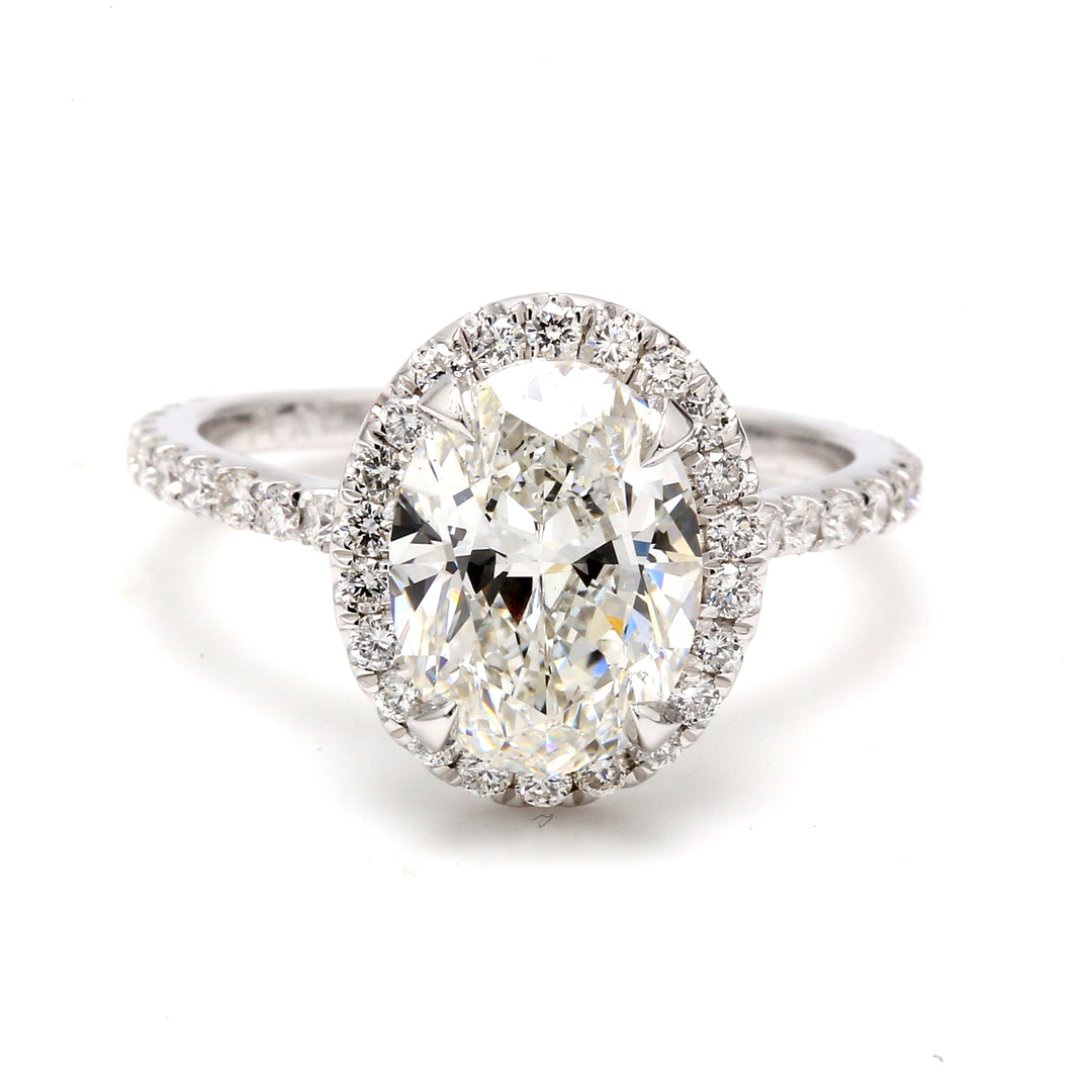 Halo ring in platinum with prong set round diamonds around claw prong set GIA certified H/VS2 oval diamond center.  D3.60ct.t.w.  (Center 3.02ct.)  Size 6.75