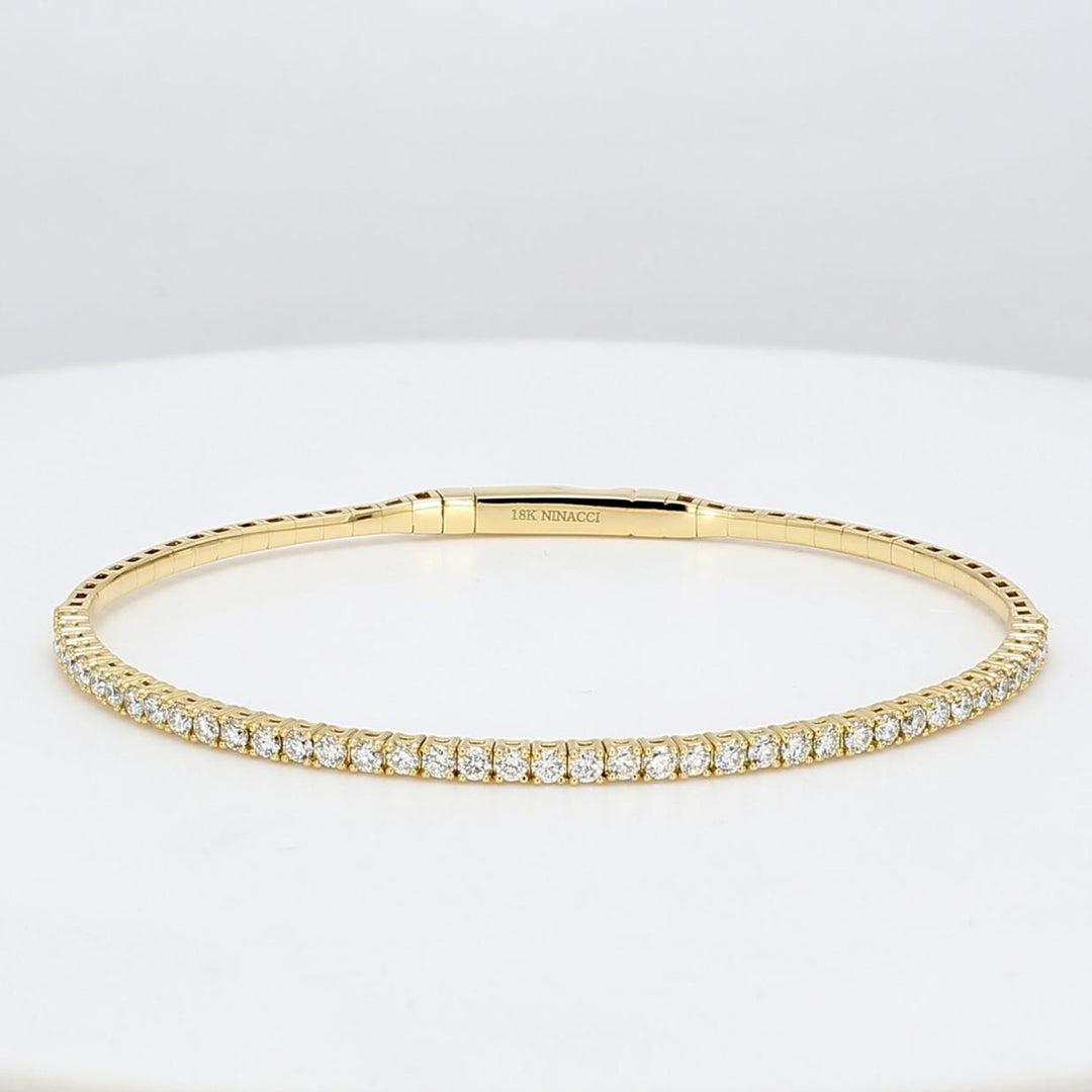 Lightweight flexible oval shaped bangle in 18K YG with prong set round diamonds.  D1.03ct.t.w.