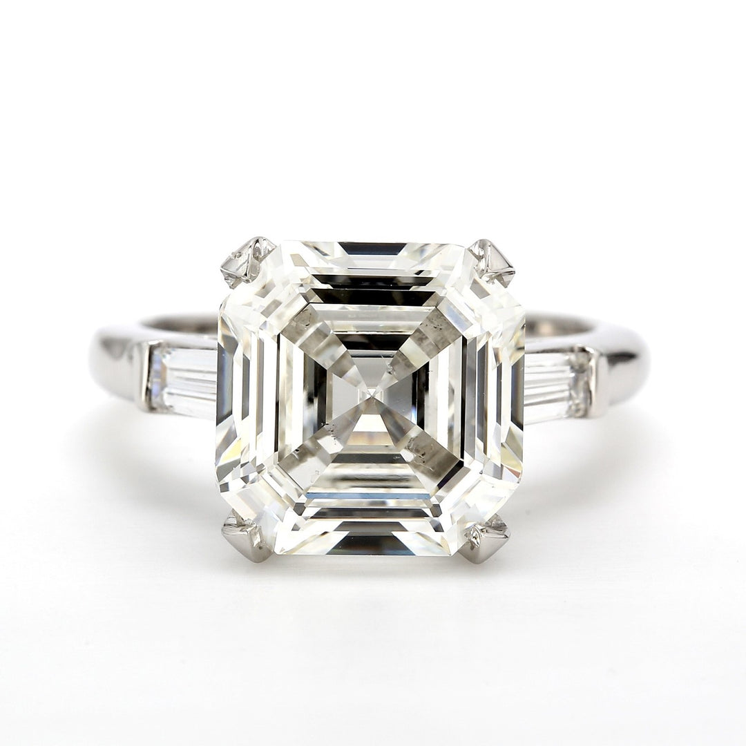 3-stone ring in platinum with claw prong set GIA certified J/SI2 asscher cut center and channel set baguette diamond sides.  D5.39ct.t.w.  (Center 5.02ct.)