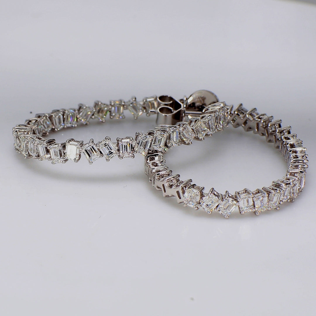 1.25"" Oval shaped inside out hoop earrings in 18K WG with prong set emerald cut diamonds.  D5.04ct.t.w.